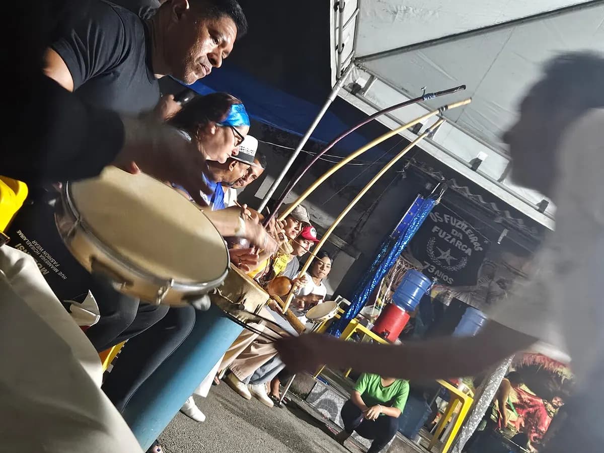 Capoeiristas tocando pandeiro e berimbaus na bateria de uma roda de capoeira no bairro da Madre Deus, em São Luís
