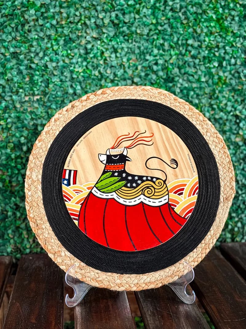 Mandala de palha com pintura de figura do Bumba Meu Boi ao centro
