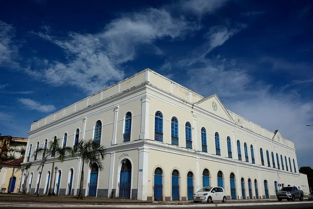 Grande casarão neoclássico creme com janelas azuis em arco, no Centro Histórico de São Luís, sob céu azul